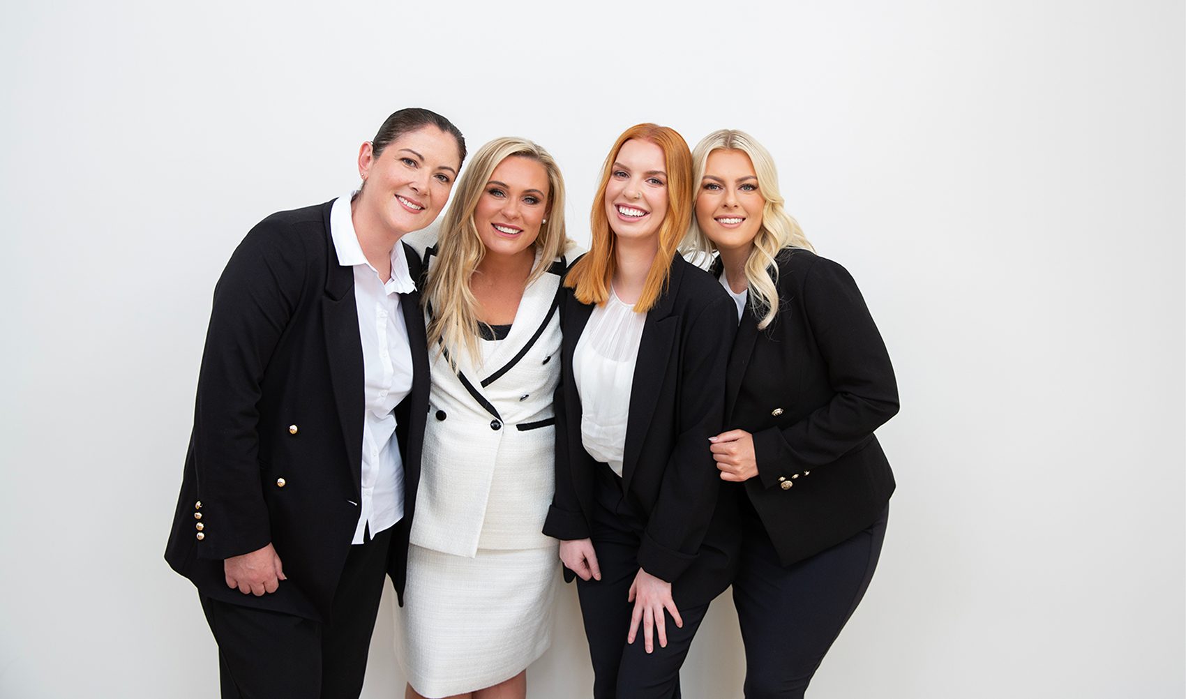 Smart Lending team of four women in business attire posing together with smiles.
